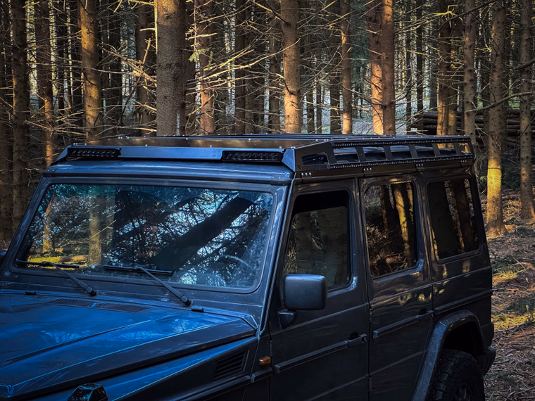 Walger Works roof rack on dark G-Class, 3/4 view in forest